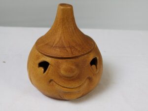 Ceramiczny lampion w kształcie uśmiechniętej dyni.