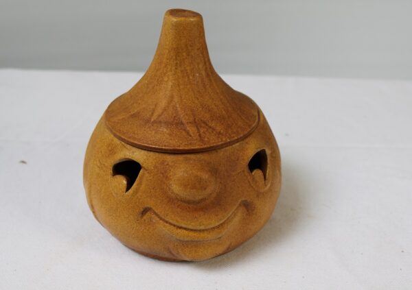 Ceramiczny lampion w kształcie uśmiechniętej dyni.